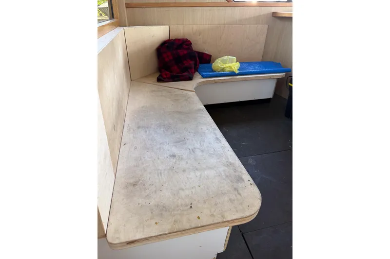 Slide: The Image of Interior seating area of a 1990 Chris-Craft 392 Commander boat with cushions and a plaid blanket. - 3