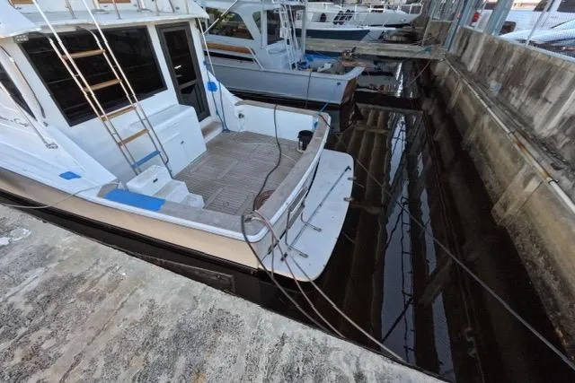 Slide: The Image of 1990 Chris-Craft 392 Commander docked, showcasing rear deck and marina setting. - 30