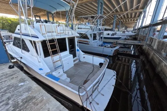Slide: The Image of 1990 Chris-Craft 392 Commander docked under a bridge, showcasing its spacious deck. - 31