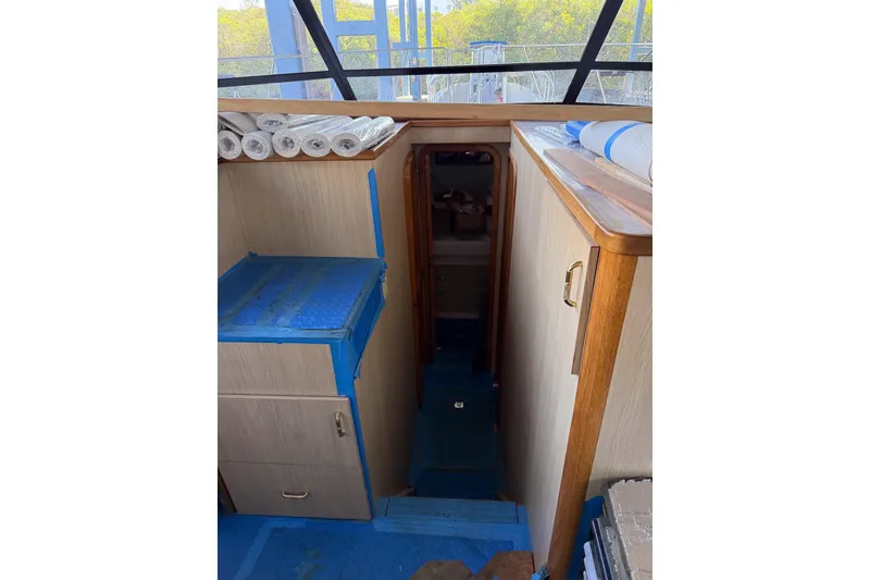 Slide: The Image of Interior view of 1990 Chris-Craft 392 Commander yacht, featuring wooden cabinetry and blue flooring. - 4