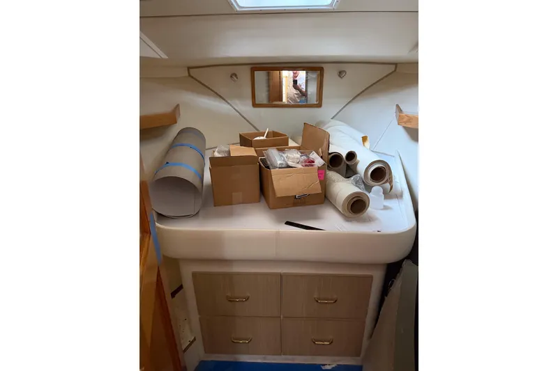 Slide: The Image of Interior of 1990 Chris-Craft 392 Commander with storage boxes and rolls on a bed. - 6