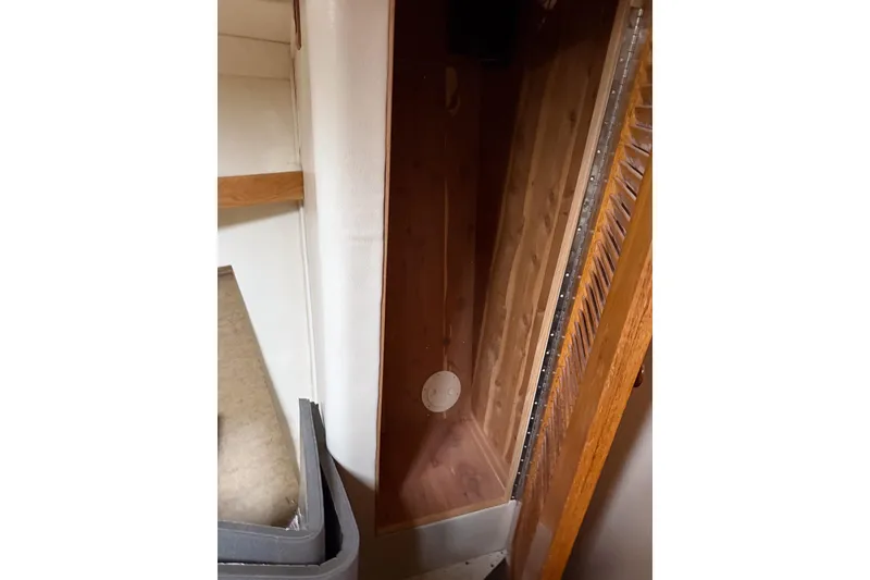 Slide: The Image of Interior view of a 1990 Chris-Craft 392 Commander, featuring wooden cabinetry and storage space. - 8