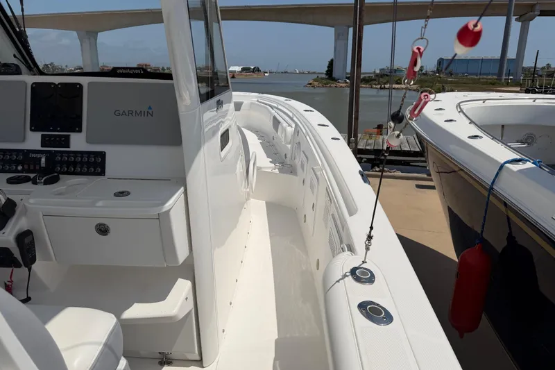 Slide: The Image of 2018 Everglades 355 Center Console boat with Garmin navigation, docked near a bridge. - 14