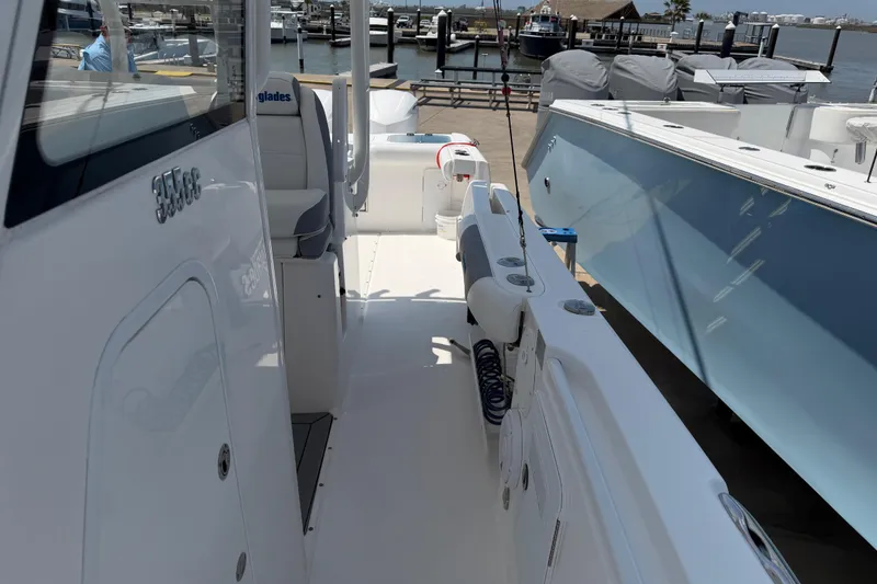 Slide: The Image of 2018 Everglades 355 Center Console boat docked at marina, showcasing sleek design and spacious deck. - 19