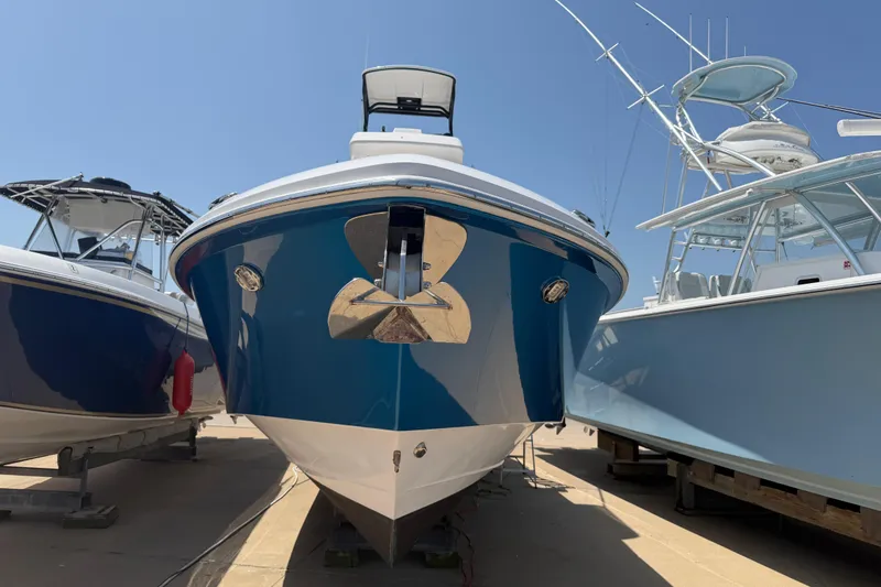 Slide: The Image of 2018 Everglades 355 Center Console boat displayed between two others under clear sky. - 2