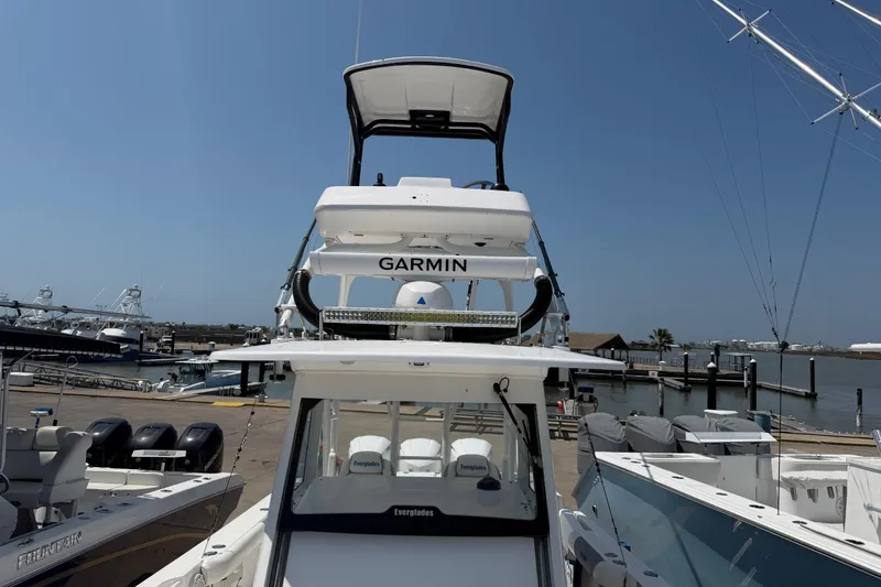 Slide: The Image of 2018 Everglades 355 Center Console boat docked, featuring Garmin equipment, under clear blue skies. - 21