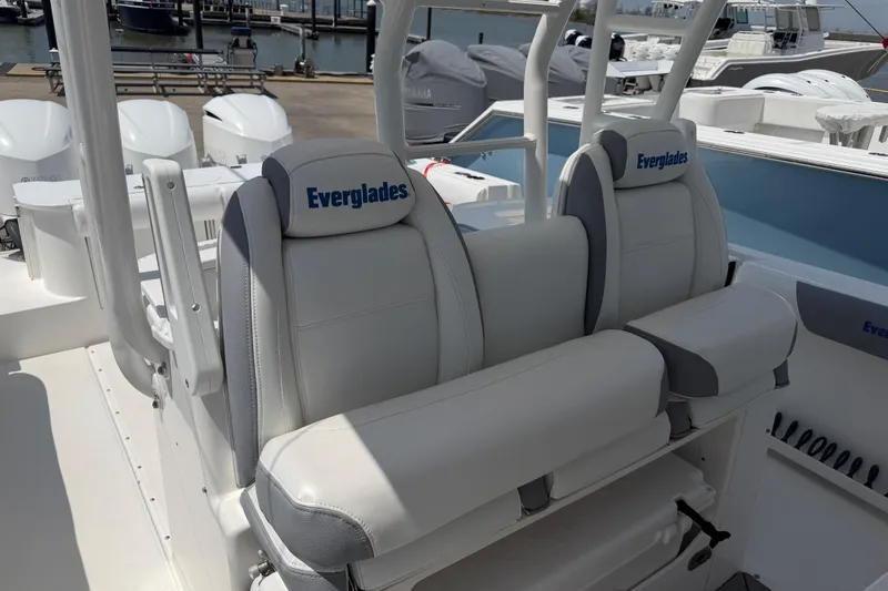 Slide: The Image of 2018 Everglades 355 Center Console boat with white seating at a marina. - 24