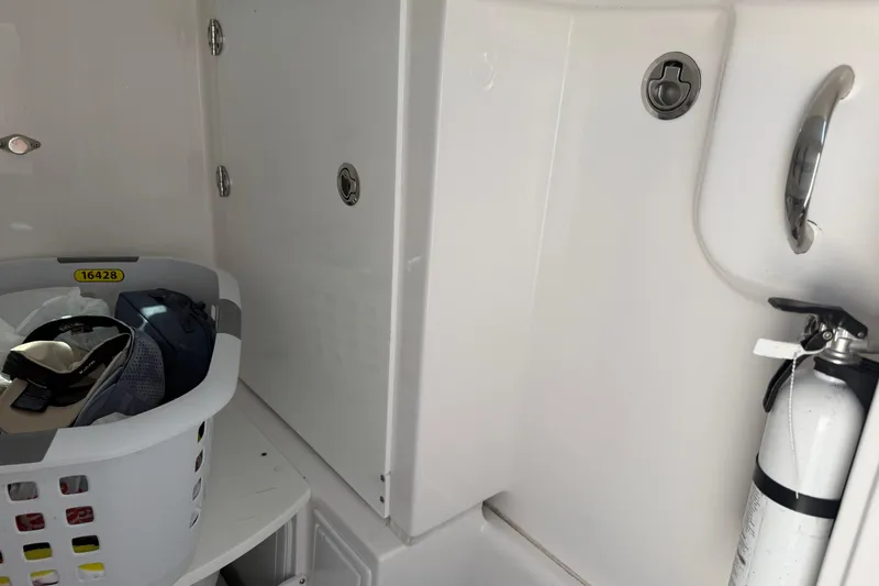 Slide: The Image of Interior of 2018 Everglades 355 Center Console with storage basket and fire extinguisher. - 25