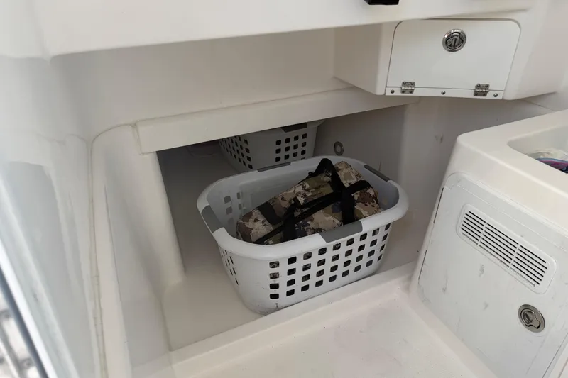 Slide: The Image of Storage area on 2018 Everglades 355 Center Console boat with laundry basket and gear. - 26