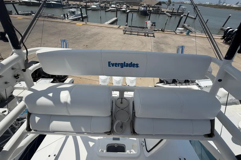Slide: The Image of 2018 Everglades 355 Center Console boat with white seating at a marina. - 59