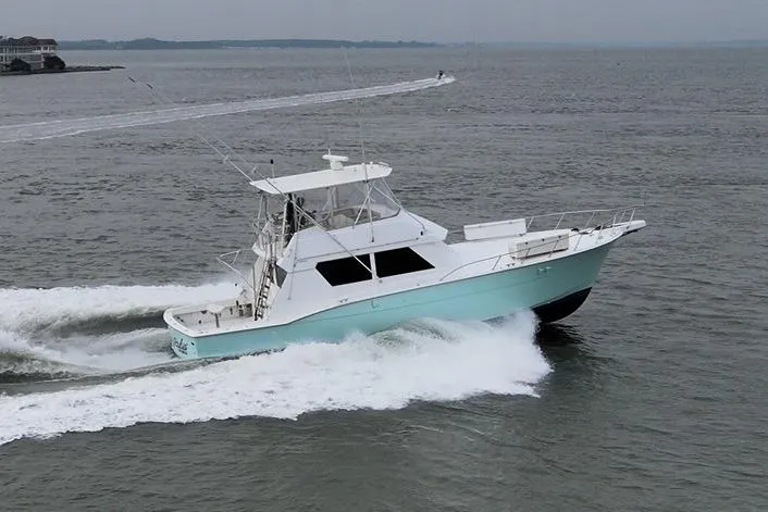 The Image of 1989 Hatteras 52 Convertible yacht cruising on open water. - 0