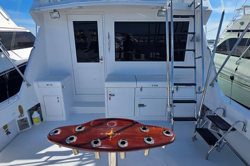 Slide: The Image of 1989 Hatteras 52 Convertible yacht deck with fishing rod holders and ladder. - 34