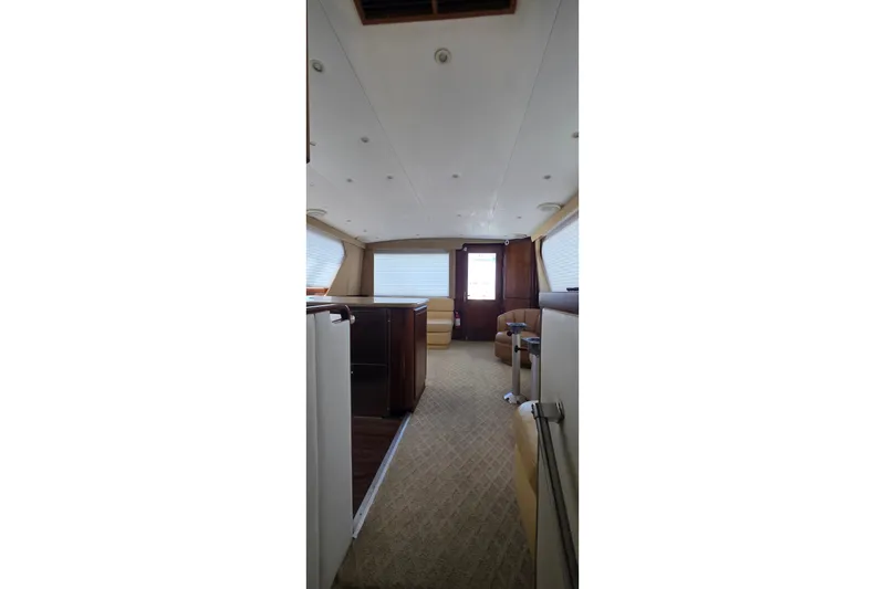 Slide: The Image of Interior of 1989 Hatteras 52 Convertible yacht, featuring elegant seating and wood finishes. - 16