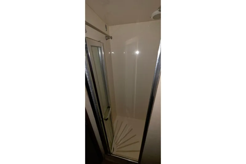 Slide: The Image of Shower area inside 1989 Hatteras 52 Convertible yacht, featuring glass door and chrome fixtures. - 25