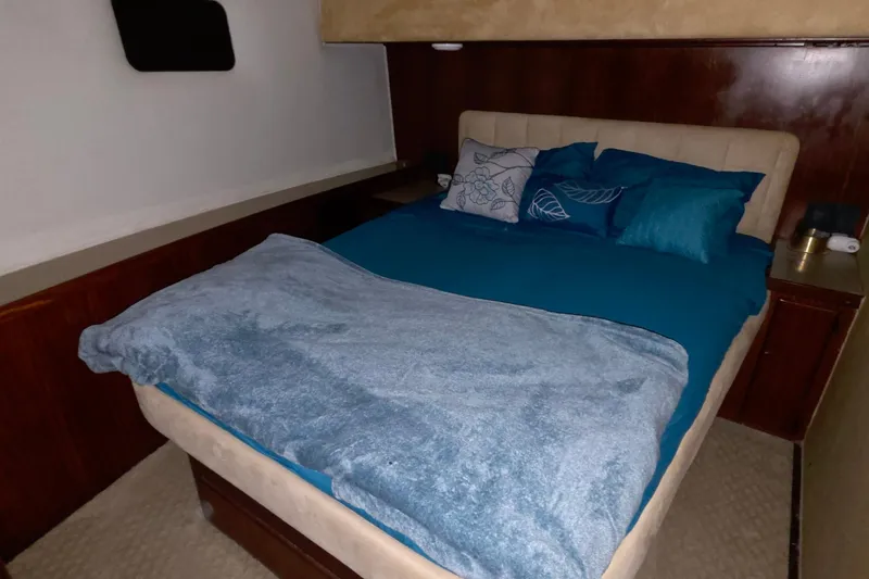 Slide: The Image of Cozy bedroom interior of 1989 Hatteras 52 Convertible yacht with blue bedding. - 22