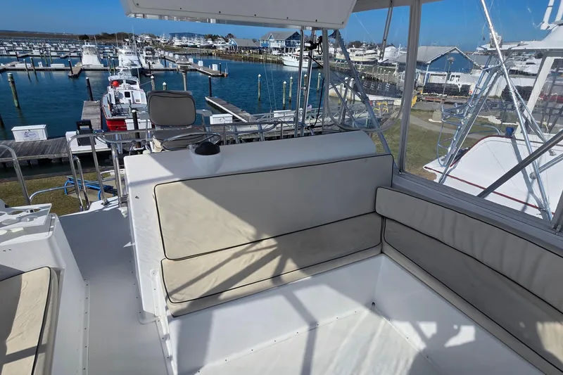 Slide: The Image of Flybridge seating area on a 1989 Hatteras 52 Convertible yacht at a marina. - 43