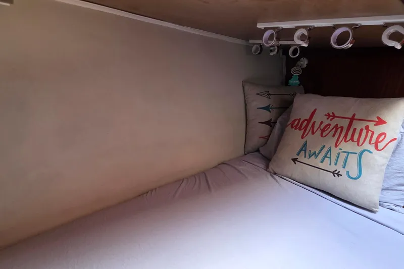 Slide: The Image of Cozy cabin bed with "Adventure Awaits" pillow on 1989 Hatteras 52 Convertible yacht. - 31