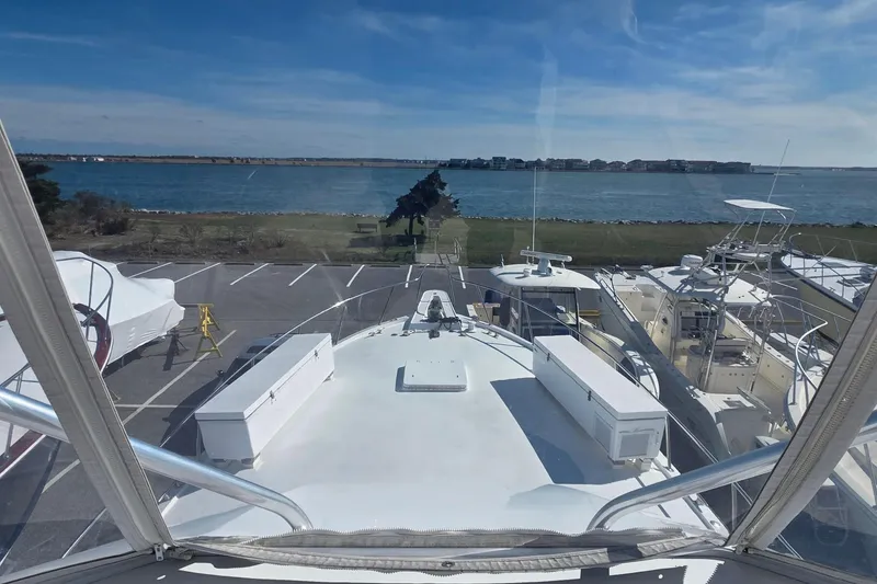 Slide: The Image of 1989 Hatteras 52 Convertible yacht docked with scenic waterfront view. - 44
