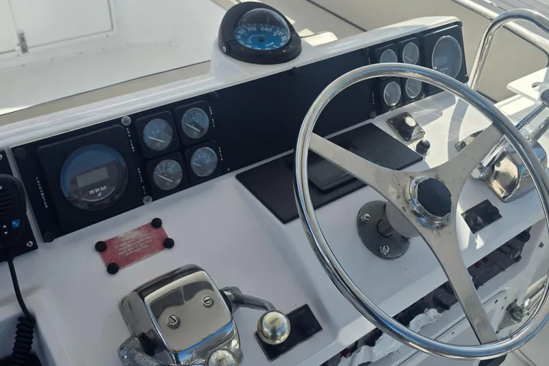 Slide: The Image of Control panel of a 1989 Hatteras 52 Convertible yacht with steering wheel and gauges. - 38