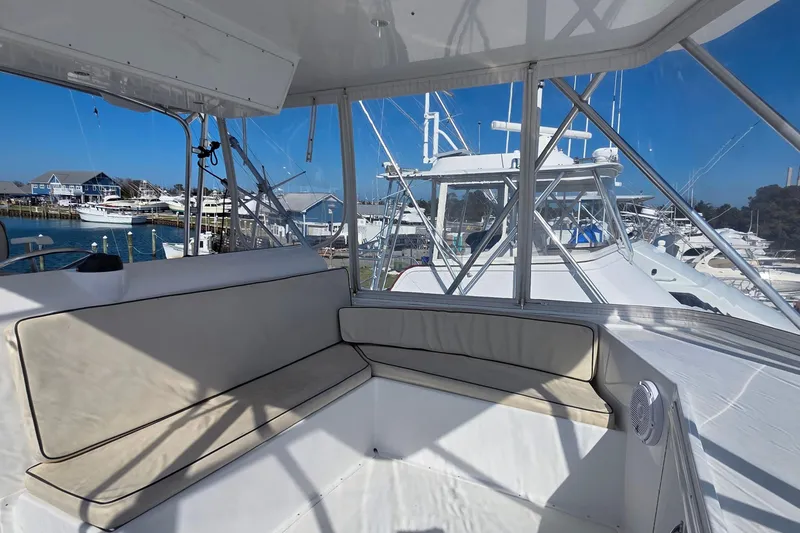 Slide: The Image of 1989 Hatteras 52 Convertible yacht interior with marina view, featuring cushioned seating. - 42