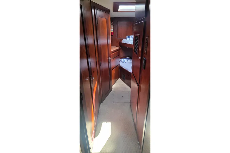 Slide: The Image of Interior hallway of 1989 Hatteras 52 Convertible yacht with wooden cabinetry and bunk beds. - 27