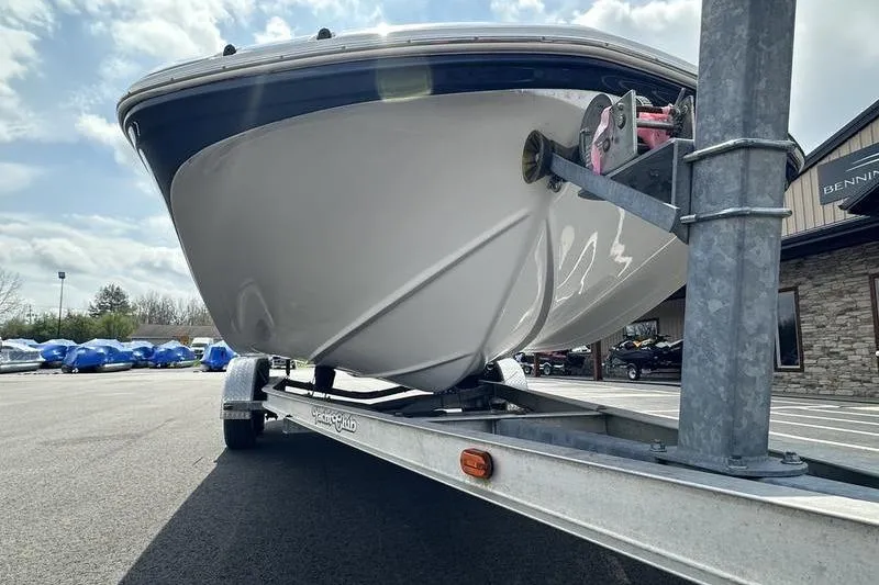Slide: The Image of 2014 Hurricane SunDeck 187 IO boat on trailer, parked outdoors under cloudy sky. - 12