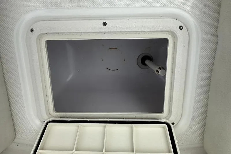 Slide: The Image of Storage compartment of a 2014 Hurricane SunDeck 187 IO boat, featuring a white interior. - 18