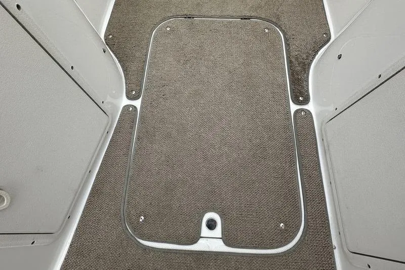 Slide: The Image of 2014 Hurricane SunDeck 187 IO boat interior with carpeted flooring and storage hatch. - 29