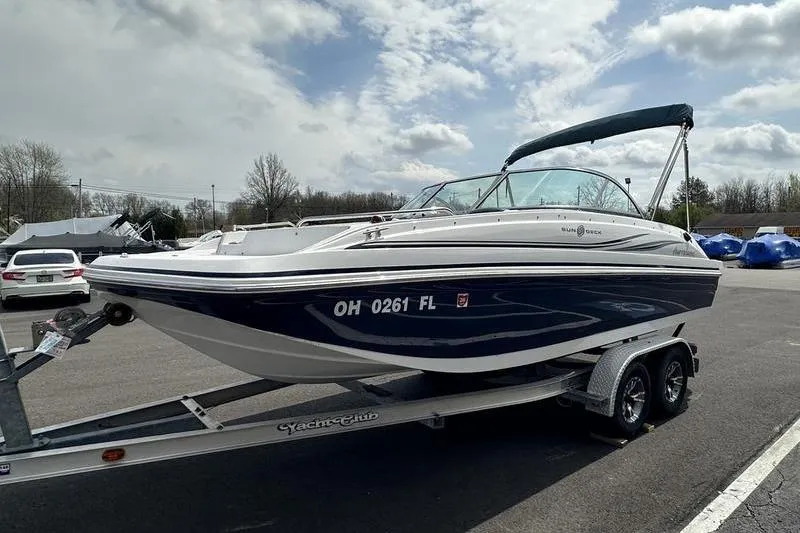 Slide: The Image of 2014 Hurricane SunDeck 187 IO boat on trailer, parked outdoors under cloudy sky. - 5