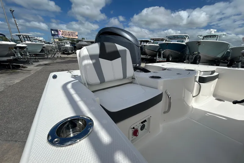 Slide: The Image of 2026 Robalo 206 Cayman boat interior with seating, docked under a cloudy sky. - 14