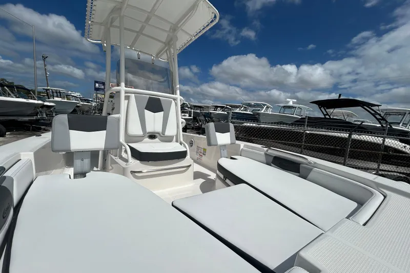 Slide: The Image of 2026 Robalo 206 Cayman boat interior with seating, under a clear blue sky. - 18