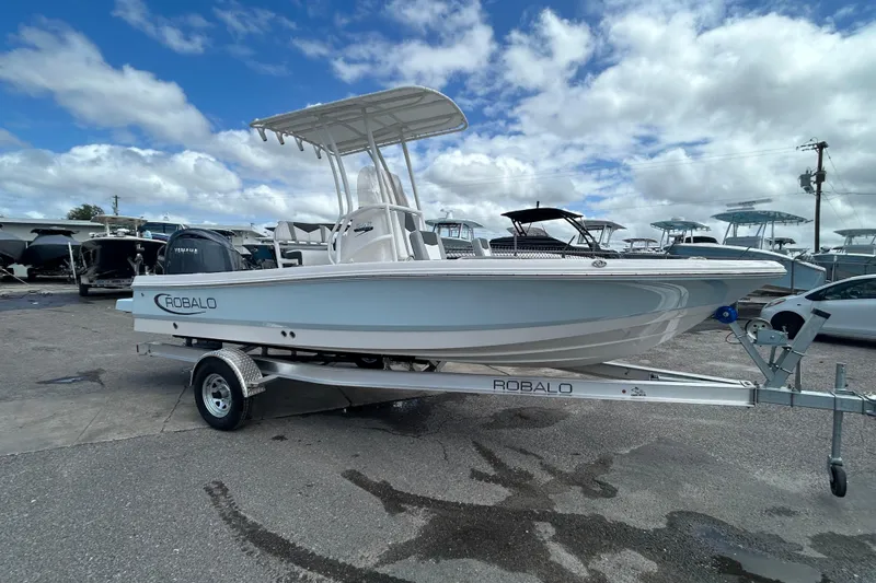 Slide: The Image of 2026 Robalo 206 Cayman boat on trailer under cloudy sky. - 2
