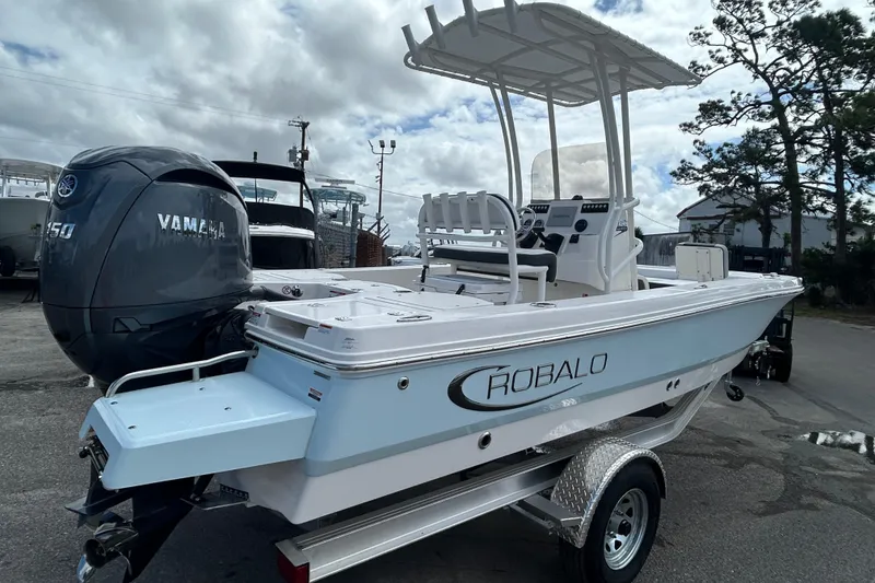 Slide: The Image of 2026 Robalo 206 Cayman boat with Yamaha engine on trailer, parked outdoors. - 6