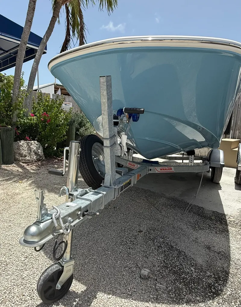 Slide: The Image of A 2026 Boston Whaler 130 Super Sport on a trailer, surrounded by palm trees. - 1