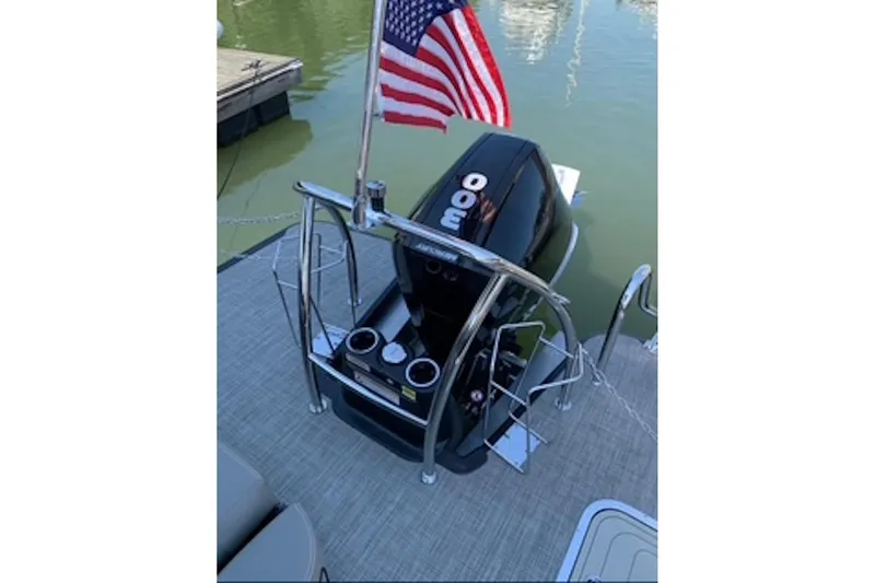 Slide: The Image of 2021 Barletta L25UE boat with American flag and powerful outboard motor. - 5