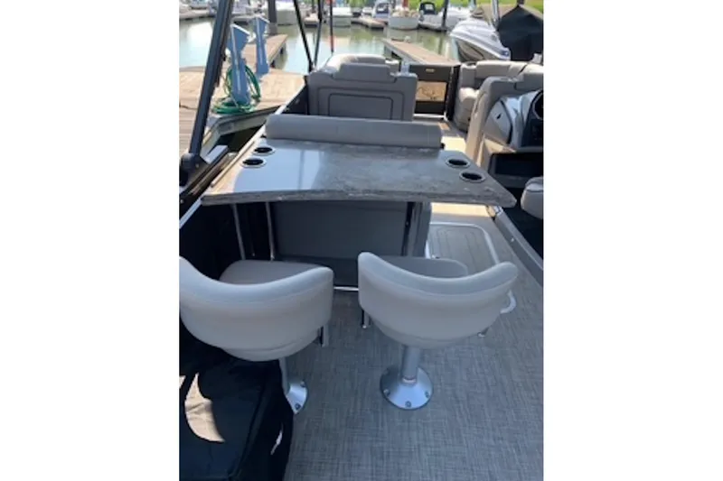 Slide: The Image of 2021 Barletta L25UE boat interior with seating and table, docked at marina. - 8