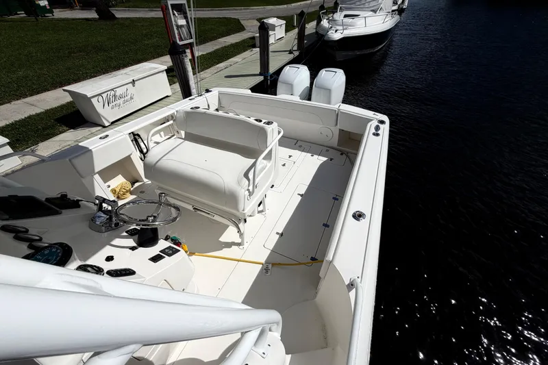 Slide: The Image of 2008 Intrepid 350 Center Console boat docked, featuring spacious deck and dual outboard engines. - 13