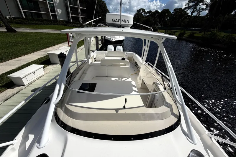 Slide: The Image of 2008 Intrepid 350 Center Console boat docked by a serene waterfront. - 24