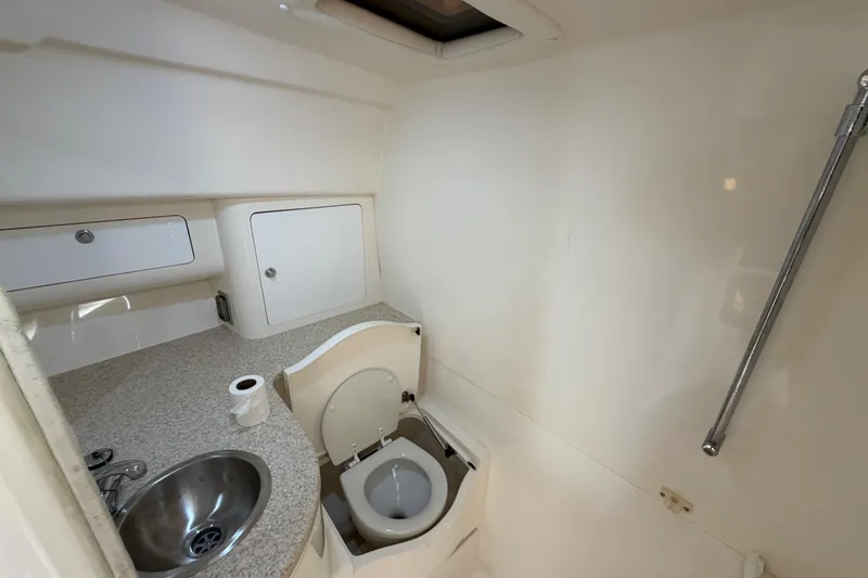 Slide: The Image of 2008 Intrepid 350 Center Console boat bathroom with sink, toilet, and storage cabinets. - 36
