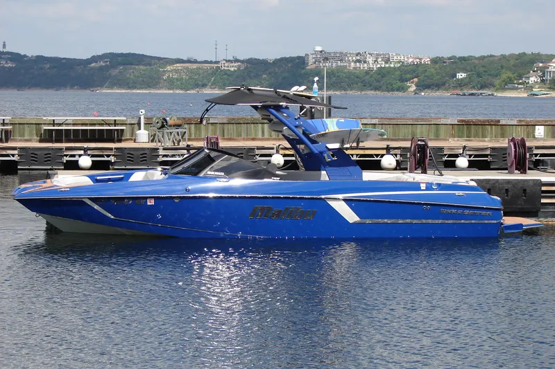 The Image of 2017 Malibu Wakesetter 24 MXZ boat docked on a calm lake. - 0