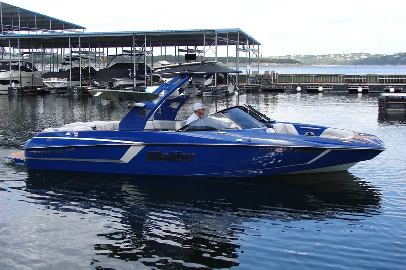 Slide: The Image of 2017 Malibu Wakesetter 24 MXZ boat docked on calm water. - 11