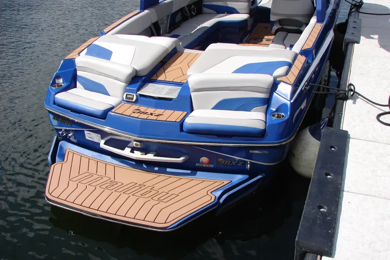 Slide: The Image of 2017 Malibu Wakesetter 24 MXZ boat docked, featuring sleek blue and white design. - 18