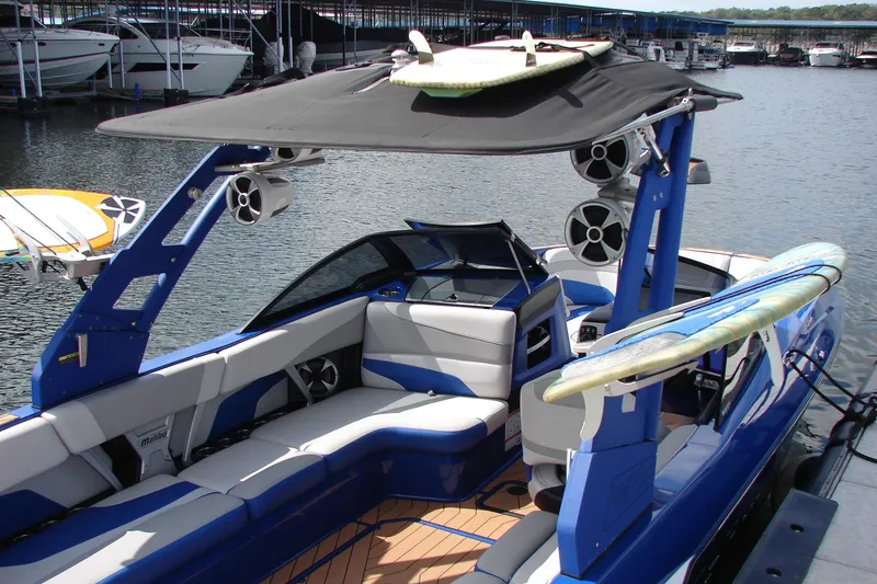 Slide: The Image of 2017 Malibu Wakesetter 24 MXZ boat with surfboards, docked at marina. - 22