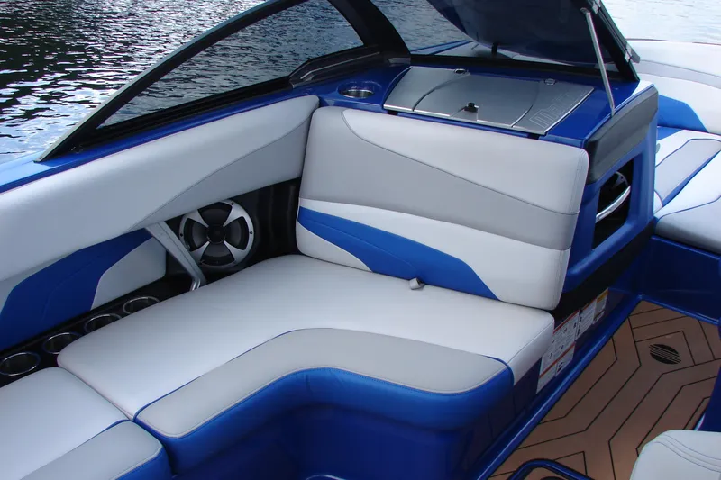 Slide: The Image of 2017 Malibu Wakesetter 24 MXZ interior with blue and white seating, cup holders, and speaker. - 26