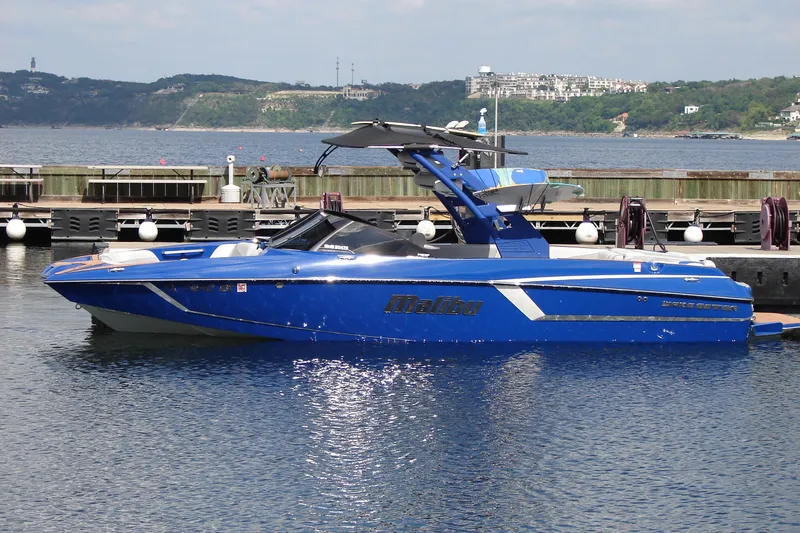 Slide: The Image of 2017 Malibu Wakesetter 24 MXZ boat docked on a calm lake. - 3