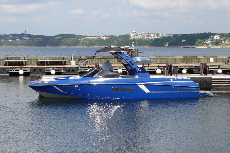 Slide: The Image of Blue 2017 Malibu Wakesetter 24 MXZ boat docked on a sunny day. - 4