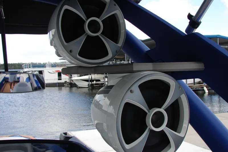 Slide: The Image of 2017 Malibu Wakesetter 24 MXZ boat speakers on a blue frame by the water. - 40