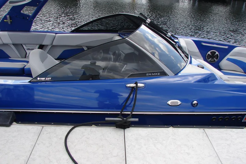 Slide: The Image of 2017 Malibu Wakesetter 24 MXZ boat docked, featuring sleek blue design and modern interior. - 48