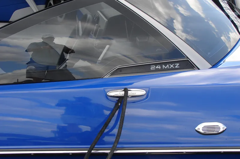 Slide: The Image of 2017 Malibu Wakesetter 24 MXZ boat, blue exterior with reflective windows. - 49