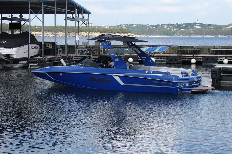 Slide: The Image of 2017 Malibu Wakesetter 24 MXZ boat docked on a calm lake. - 5